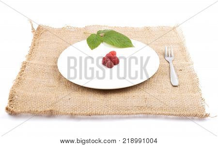 Colorful and crisp image of red raspberries on plate and jute