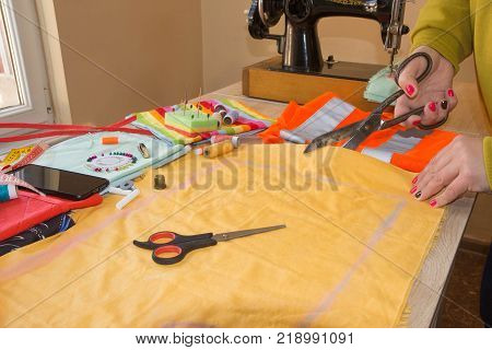 Tailor working in his shop. fabric he has marked out the pattern of the garment he is making with tailors chalk. tailoring concept