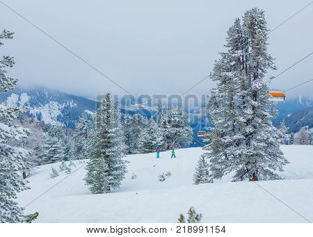 Chair lift with skiers at Alps ski resort