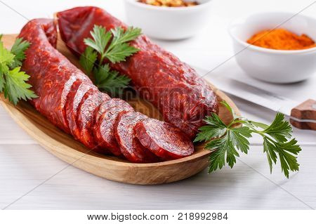 Traditional Hungarian paprika sausage. Smoked pork salami on white.