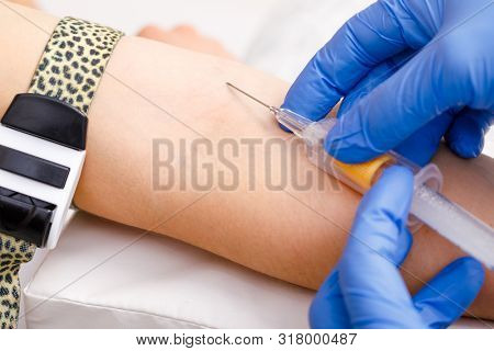 Close-up shot of doctor or nurse ready to take a blood sample from arm vein with a vacutainer. Venipuncture or venepuncture procedure