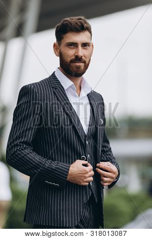 Confident Businessman. Confident Young Man In Full Suit Adjusting His Sleeve And Looking Away While 