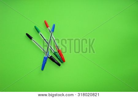 Colored Writing Pens. Colorful Items For School, Office On A Green Background.