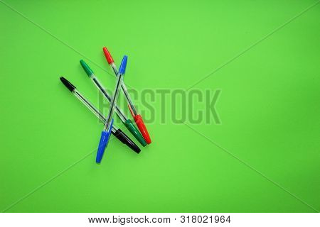 Colored Writing Pens. Colorful Items For School, Office On A Green Background.