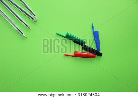 Colored Writing Pens. Colorful Items For School, Office On A Green Background.
