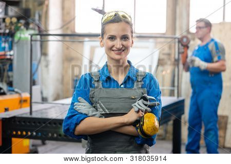Workers in a metal workshop, man and woman
