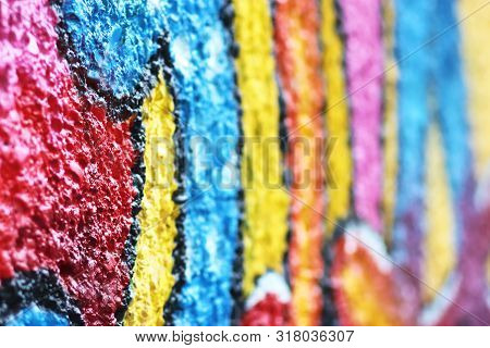Multi Colored Graffito On A Rough Wall, Side View, Background With Copy Space