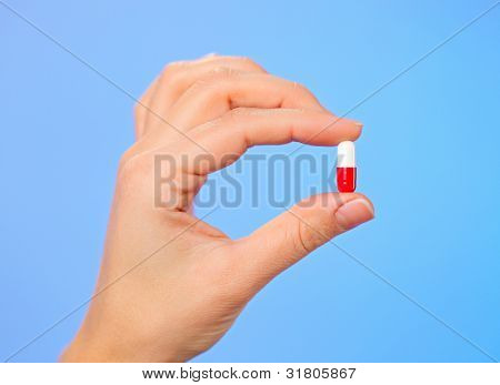 Rote und weiße Bolus (Kapsel) in der Arzt-Hand, Makro-Ansicht