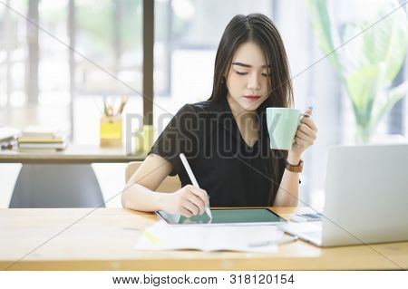 Young Asian Graphic Designer Working On Computor And Graphics Tablet In Her Working Space