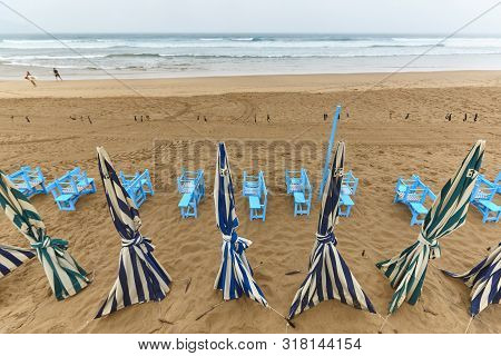 Zarautz Village Sand Beach With Umbrellas Cloudy Day. Euskadi, Spain