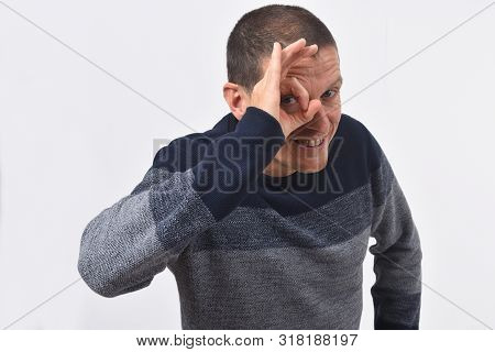 Man Looking Through Fingers As If Wearing Glasses On White Background