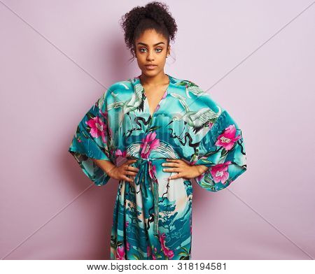 Young beautiful african american woman standing wearing elegant colorful caftan