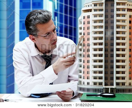 Architect met een breadbord model van een gebouw