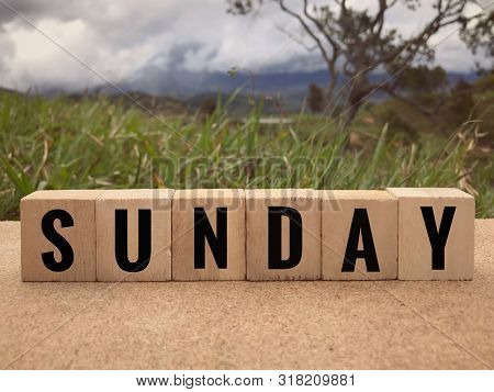 Day And Time Concept - Sunday Written On Wooden Blocks. Blurred Styled Background.