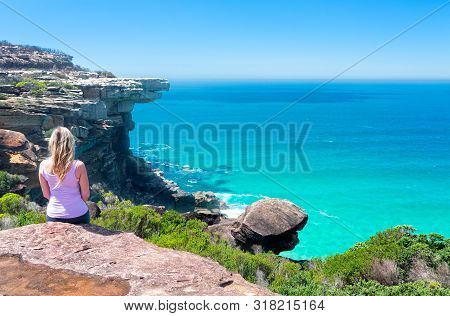 A Female Sitting On Cliffs By The Ocean With Views To Eagle Rock And Below Lovely Clarity In The Wat