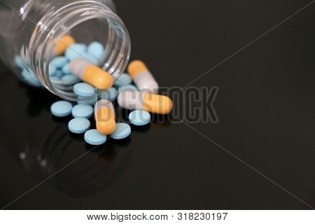 Pills In A Bottle, Medication In Capsules On A Dark Glass Table. Concept Of Pharmacy, Antibiotics, V