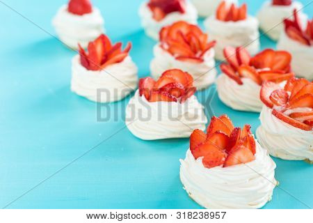 Beautiful Pavlova Cakes With Strawberries On A Blue Background. Selective Focus. Tasty Sweet Breackf