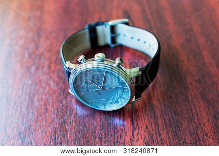 Brown Leather Watch Strap On Mens Luxury Watch Laying On Dark Rustic Wooden Table. Close Up. Copy Sp
