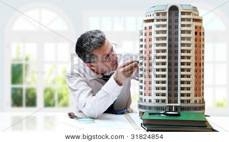 Architect met een breadbord model van een gebouw