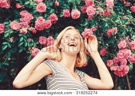Perfume And Cosmetics. Woman In Front Of Blooming Roses Bush. Blossom Of Wild Roses. Secret Garden C