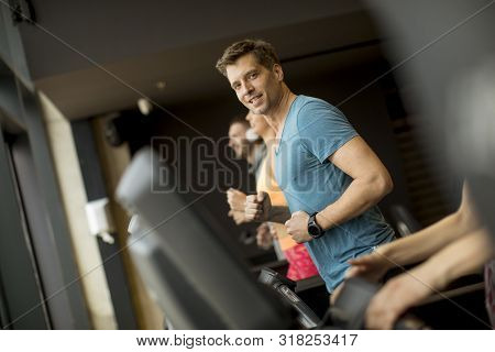Young People Using Threadmill In Modern Gym