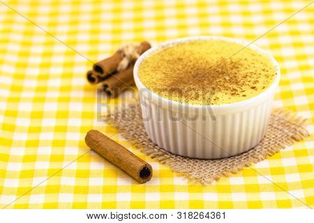 Dessert Of Curau. Brazilian Sweet Corn, Corn Mousse With Cinnamon On A Wooden Background. Typical Br