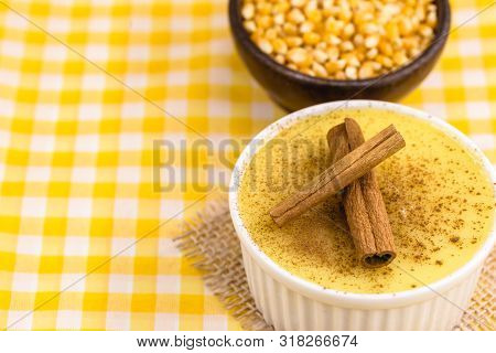 Dessert Of Curau. Brazilian Sweet Corn, Corn Mousse With Cinnamon On A Wooden Background. Typical Br