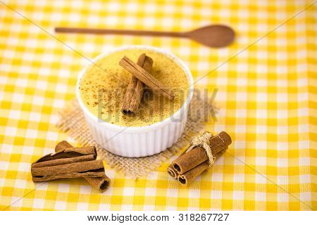 Dessert Of Curau. Brazilian Sweet Corn, Corn Mousse With Cinnamon On A Wooden Background. Typical Br
