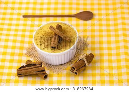 Dessert Of Curau. Brazilian Sweet Corn, Corn Mousse With Cinnamon On A Wooden Background. Typical Br