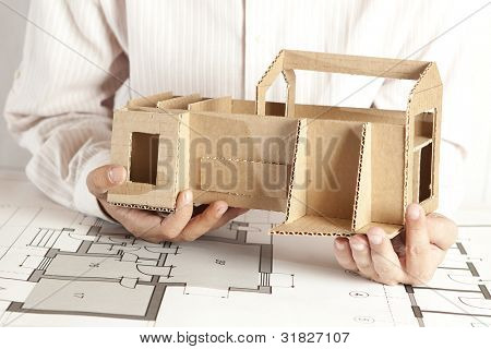 En mandlig arkitekt ser på en model hus
