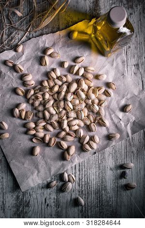 Pistachios On Wooden Table In The Foreground With Darkened Background