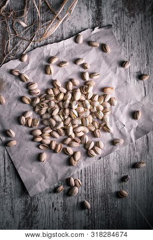 Pistachios On Wooden Table In The Foreground With Darkened Background