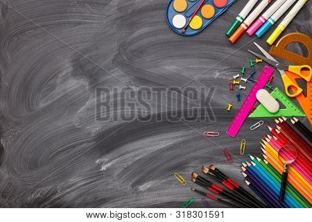Stationery accessories on background of school blackboard. Top view, copy space. School accessories for children's education and development.  Office supplies.