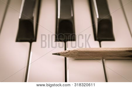Old Pencil On White Keys Of Electric Piano In Horizontal View. Concept About Piano Playing Or Piano 