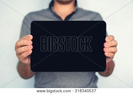 Young Male Holds A Touch Pad Tablet On Isolated White Background. Large-size Digital Tablet With Bla