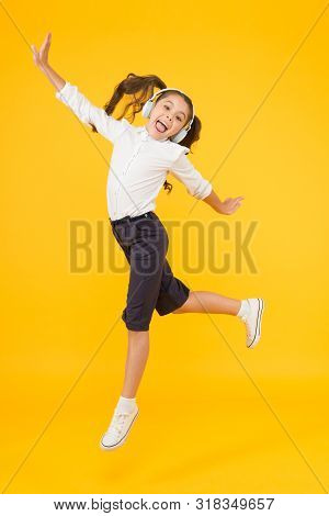 Dancing Class. Small Dancer Moving To Music On Yellow Background. Little Child Enjoy Dancing To Mode