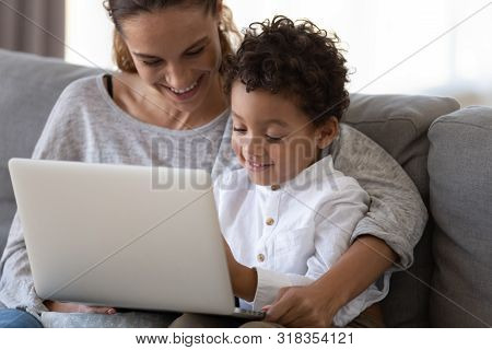 Happy Mother Embrace African Cute Kid Son Learning Using Laptop