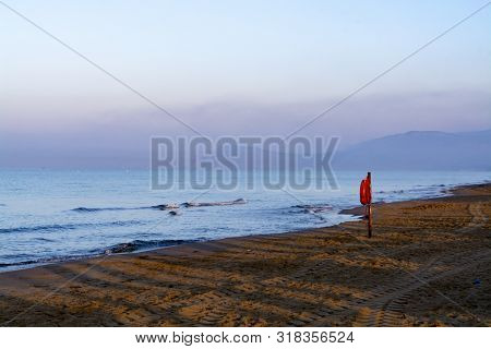 Unidentified Man Jogging In Orange Sportswear On Sandy Beach On Sinrise Over Sea Or Ocean