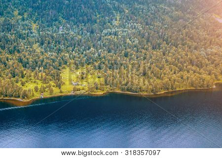 Small Alone House In The Teletskoe Lake At The Altai Mountains Near The Lake Surrounded By Green Tre
