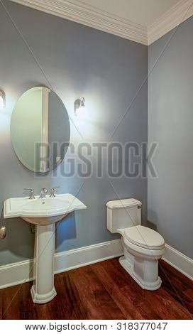 Simple half bathroom interior with light blue walls.