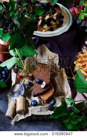 Norwegian Cheese Brunost On The Cutting Board .style Rustic.selective Focus
