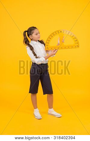 Setting Square With Protractor. Little Girl Using Triangle To Measure Angles In Degrees On Yellow Ba