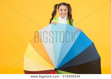 Symbol Of Protection. Hiding From Rain. Smiling Schoolgirl Peeking Out Of Colorful Umbrella. Autumn 