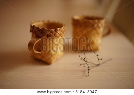 Two Wicker Mugs And A Dry Flower On The Table, A Beautiful Still Life