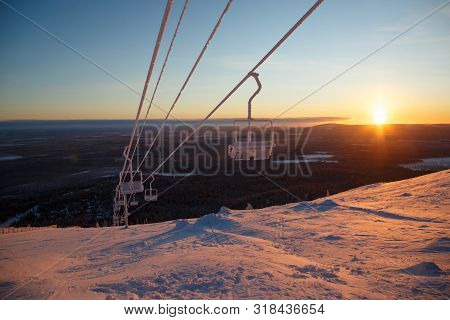 Snowboarder Ride On The Top Of Snowy Hill In Ski Resort During Calm Winter Sunset. Scenery Of Athlet
