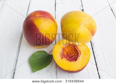 Delicious And Juicy Peach (nectarina) On White Wooden Table With Place For Text.