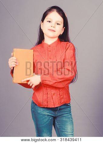 Published Information. Small Child Holding Book With Orange Cover For Vital Information. Little Girl