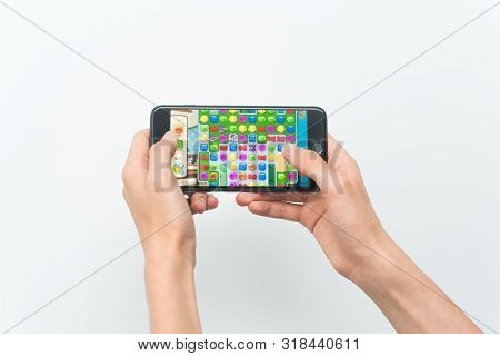 Samara, Russia -07, 29, 2019: A Young Guy Playing Homescapes Game On Iphone 8 Plus. Teenage Boy Hold