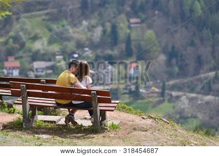 Bad Wildbad, Germany - April 22, 2019: A Guy And A Girl Are Sitting On A Bench And Admiring, The Bea