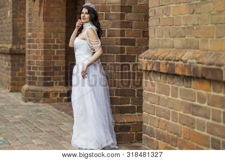 Portrait Of Sensual Caucasian Bride With Crown And Necklace Posing Against Old Brick Wall Outdoos.ho